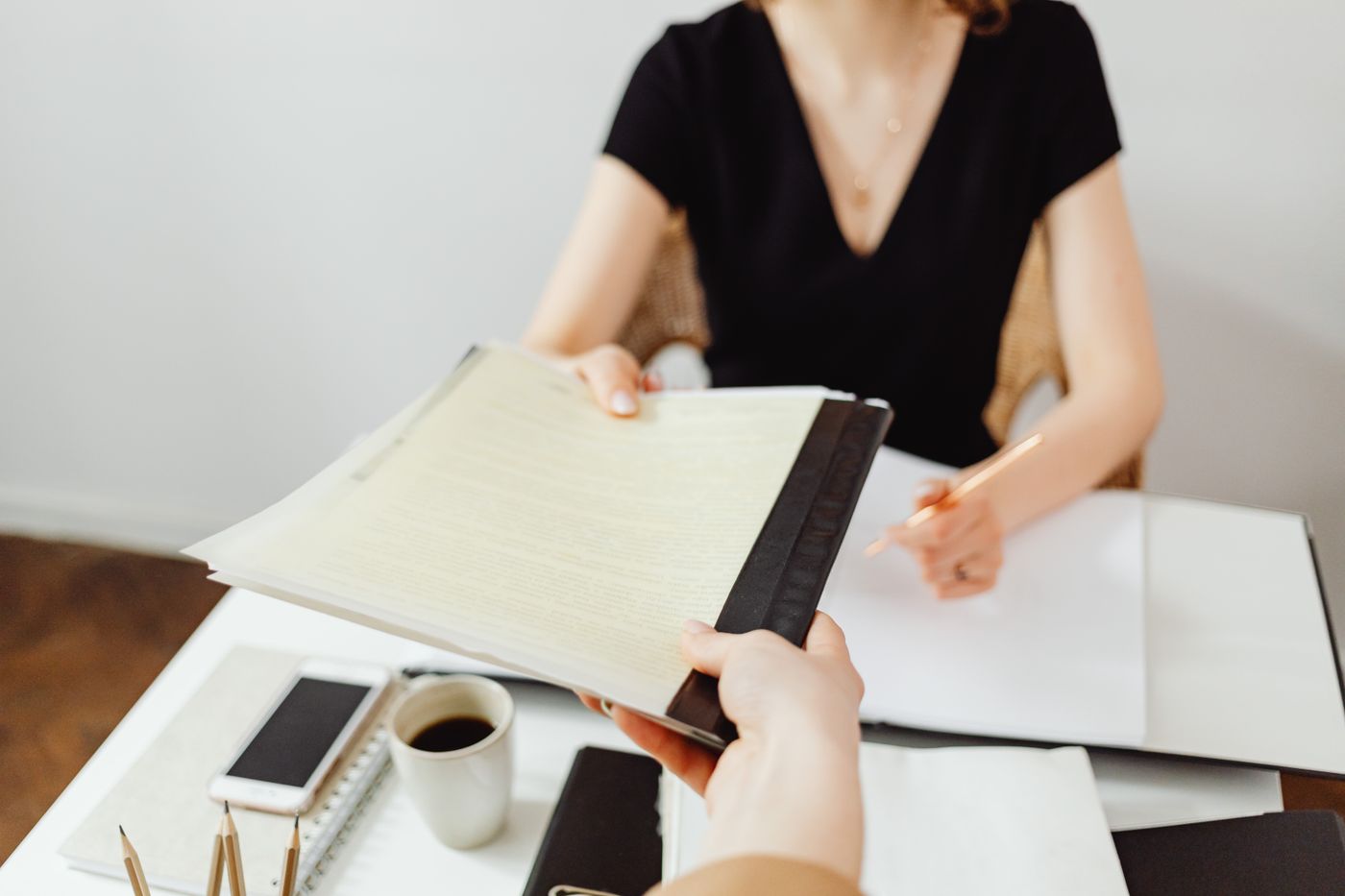 Nhân sự văn phòng đối chiếu danh sách và bộ hồ sơ giấy trước khi nộp